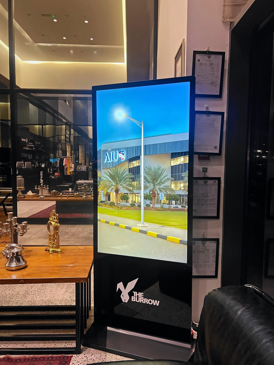 AIU's campus ad on a portrait standing screen in the reception of a mixed gym